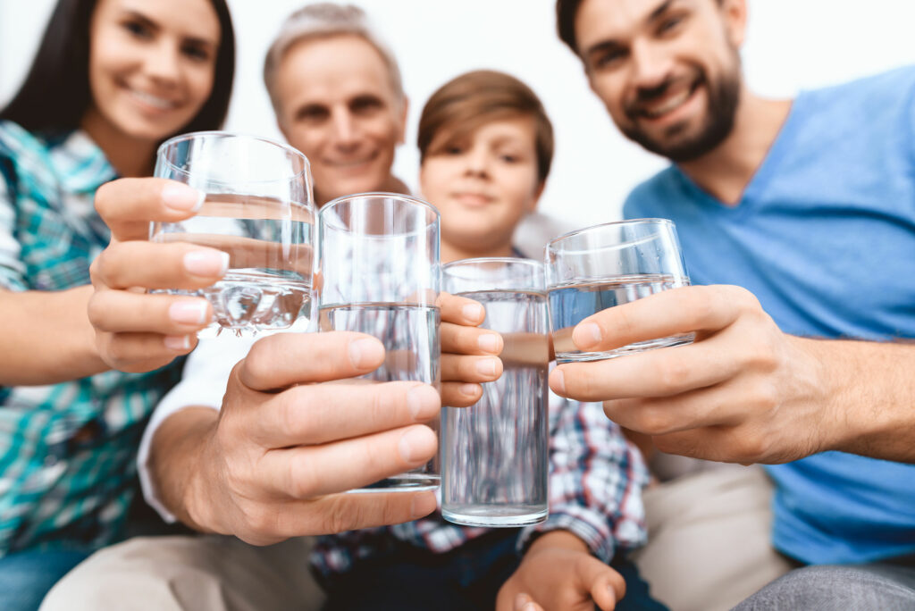 close-up-cheerful-family-cheering-with-glasses-water